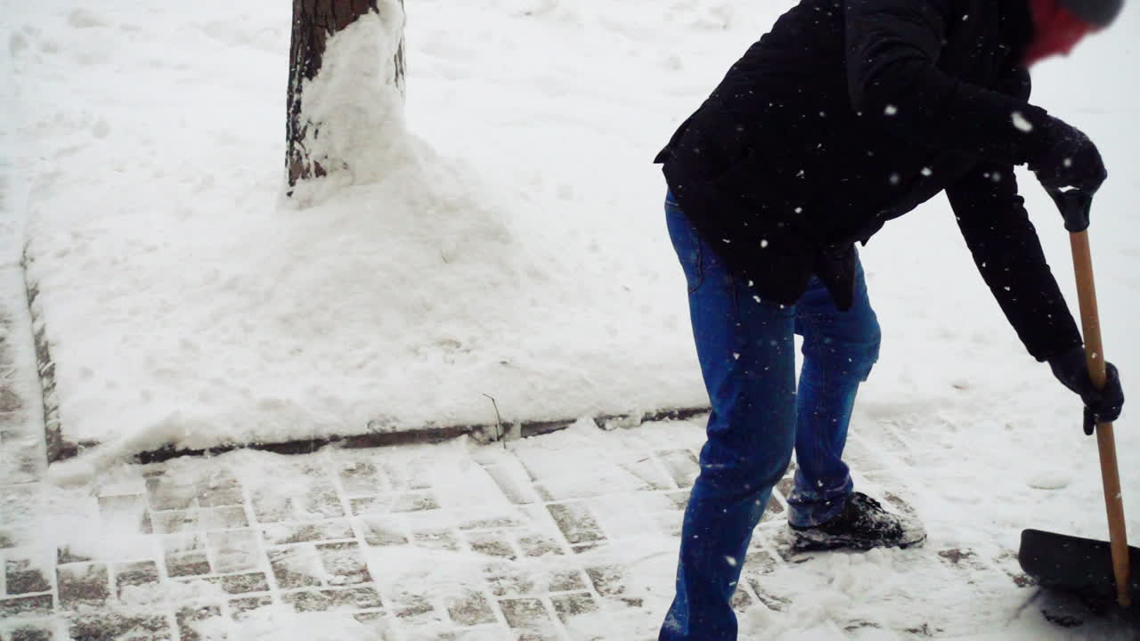 Den ukendte mand renser gaden for sne. Slowmotion