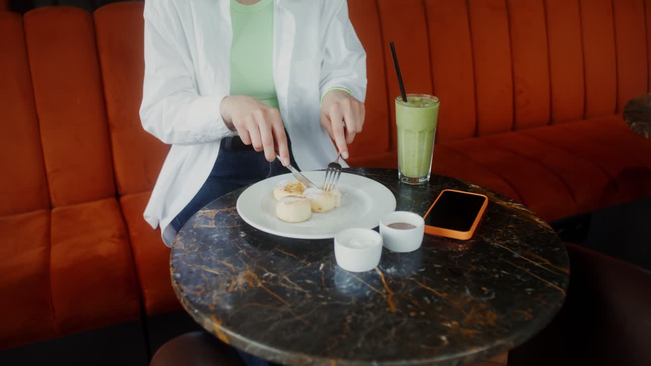 Woman Eating Pancakes and Drinking Smoothie at a Cafe