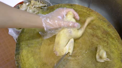 cutting parts of a cooked goose with a butcher's knife - top view