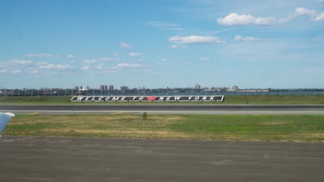 Bienvenido-Al-Cartel-De-Nueva-York-En-El-Aeropuerto-De-Laguardia-Con-Vista-Al-Río-Este