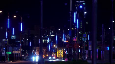 city street at night with colorful illuminated poles