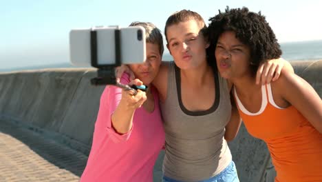 mujeres deportivas tomando selfies con selfiestick