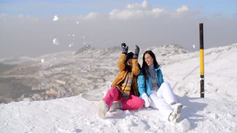 dos mujeres jóvenes divirtiéndose en la nieve de invierno