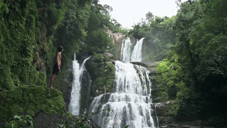 hombre mira a las cascadas de nauyaca selva tropical de costa rica, cámara lenta