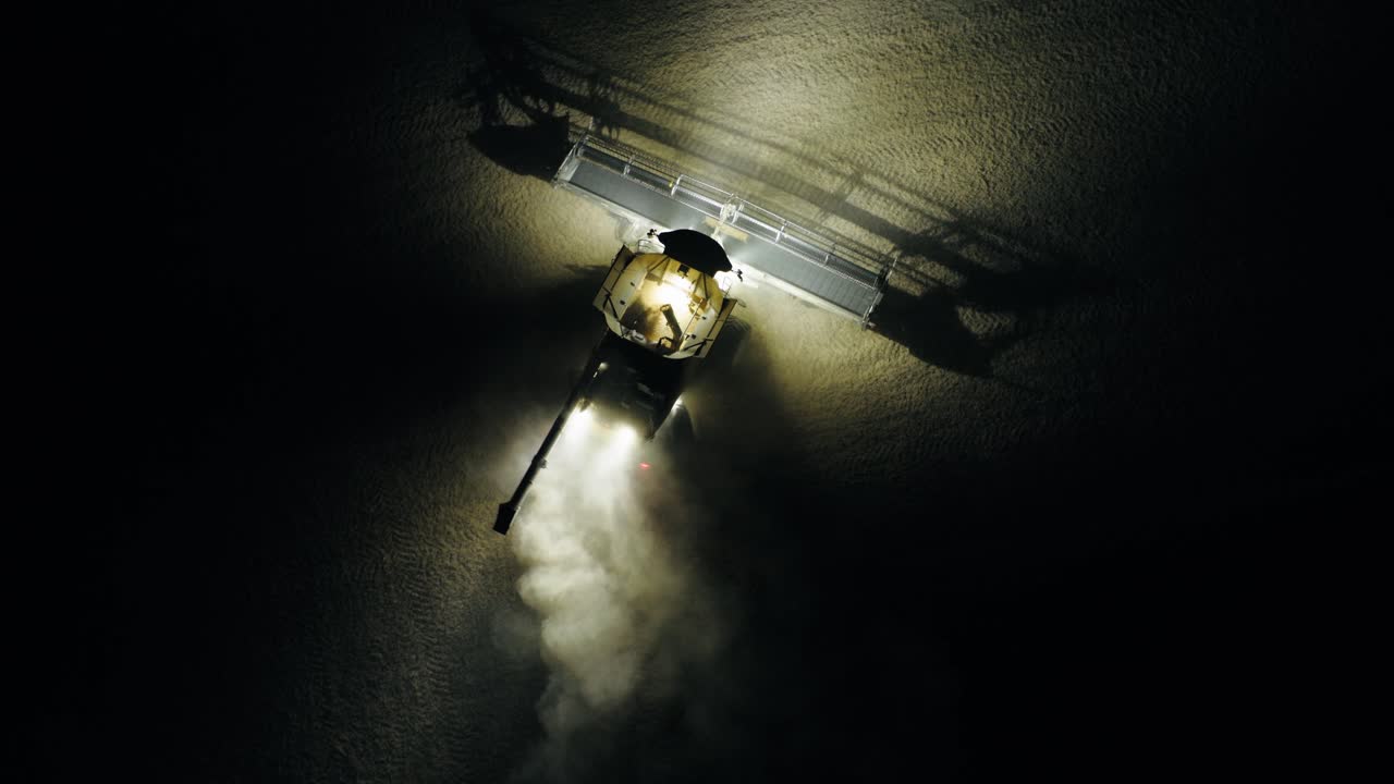 A combine finishes his row at night