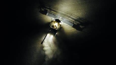 A combine finishes his row at night