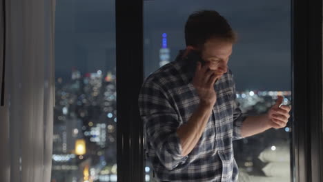 Man-talking-on-the-phone,-Manhattan-skyline-view-at-night