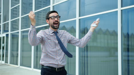 Man Celebrating with Money Outside an Office Building
