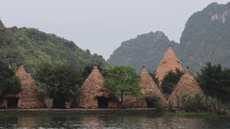 a tranquil river scene with distinctive conical buildings.