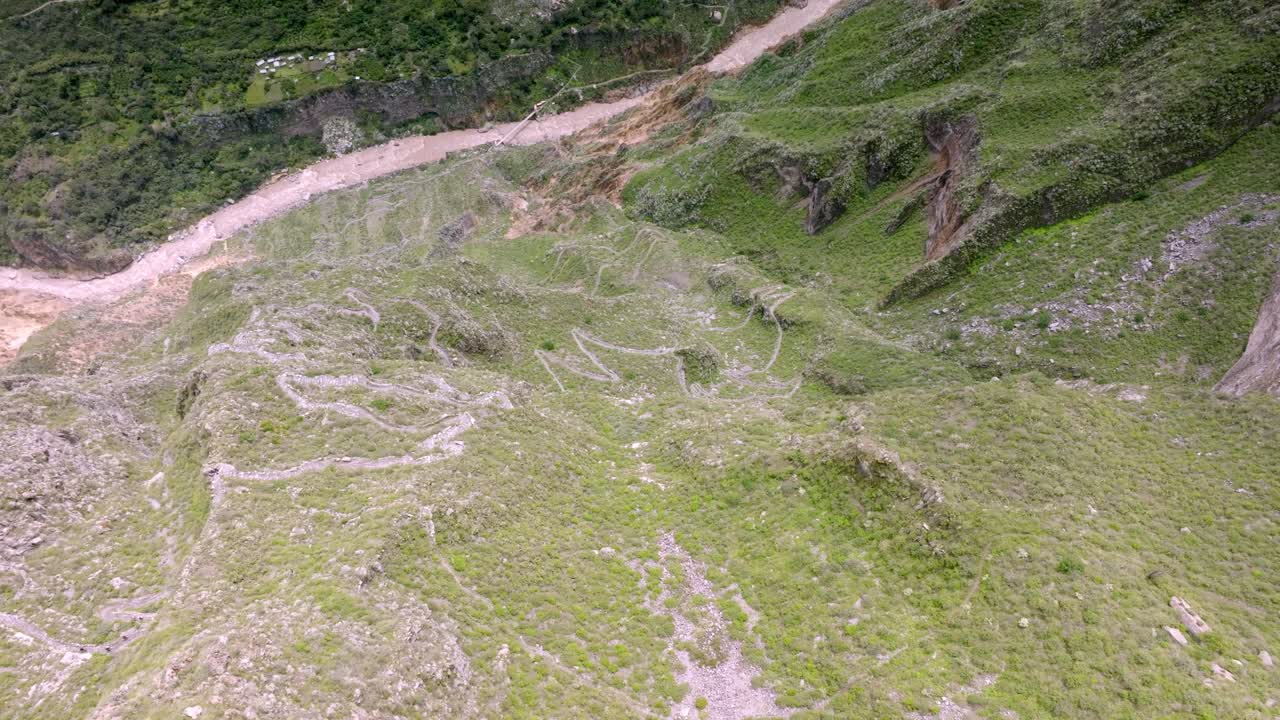 Drone shot from above, capturing the trekking path leading to San Miguel, with the stunning Colca River flowing in the background, showcasing the rugged beauty of the Colca Canyon.