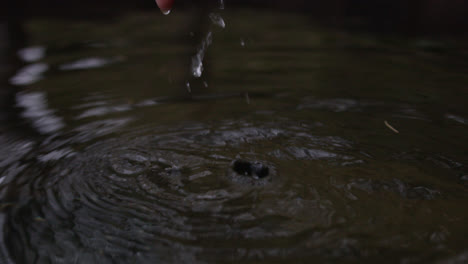 Weibliche-Hand-Taucht-Aus-Wasser-Auf-Und-Bildet-Tröpfchen-In-Zeitlupe