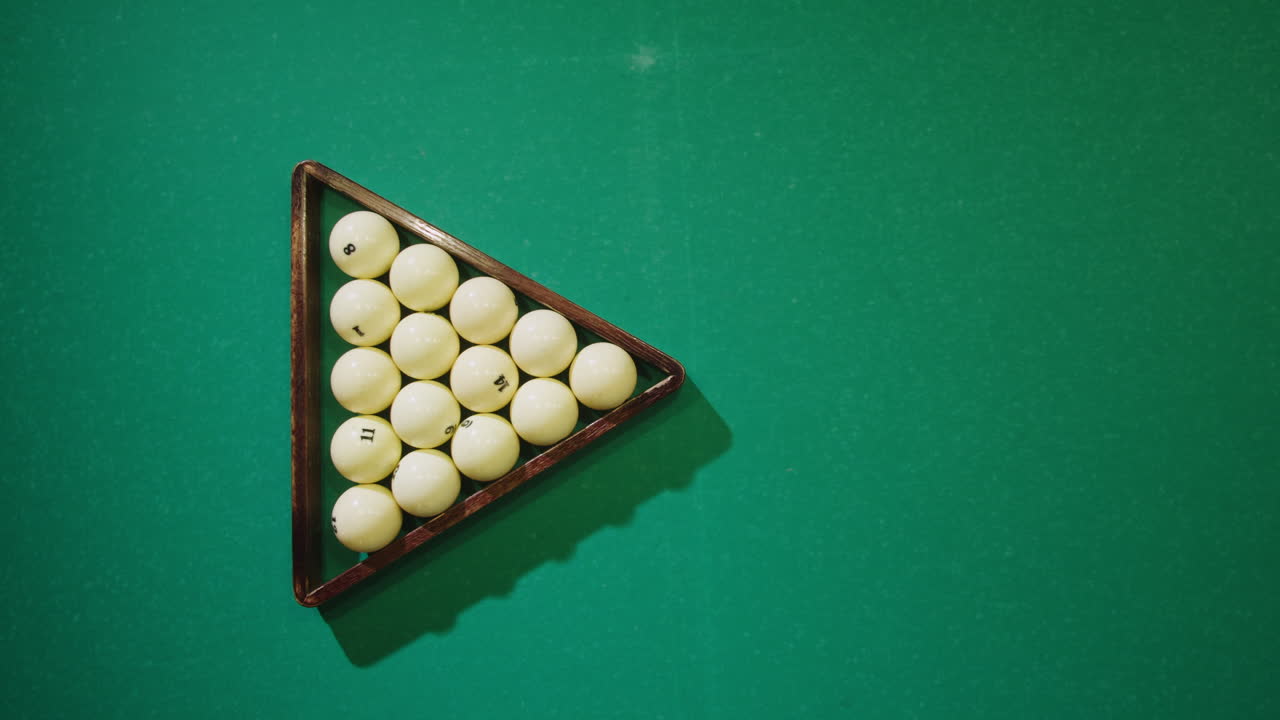 Breaking white pool balls top view on green billiards table for start to play. Russian biliard game, Russian pyramid. Billiard balls with numbers on a pool table. Billiards team sport. High quality 4k footage