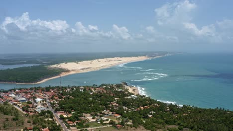 Dron-Aéreo-Rotatorio-Plano-Extremo-De-La-Ciudad-De-Playa-Tropical-De-Tibau-Do-Sul-En-Rio-Grande-Do-Norte,-Brasil-Con-Las-Dunas-De-Arena-De-Malembá,-El-Océano-Atlántico-Y-La-Laguna-De-Guaraíras-Al-Fondo