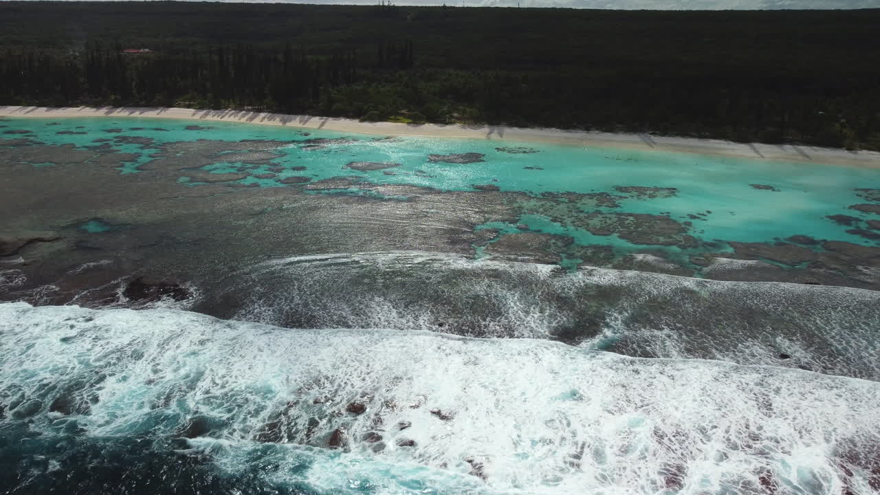 toma aérea de olas rompiendo sobre el arrecife en la playa apartada de yejele, nueva caledonia
