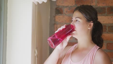 caucasian vlogger woman drinking water at home.