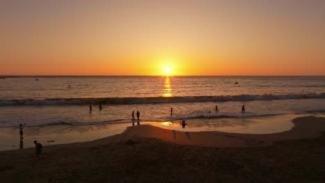 toma aérea de turistas divirtiéndose en la costa durante la puesta de sol en chile