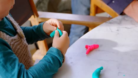 un niño pequeño jugando con arcilla en un hogar cómodo 4k