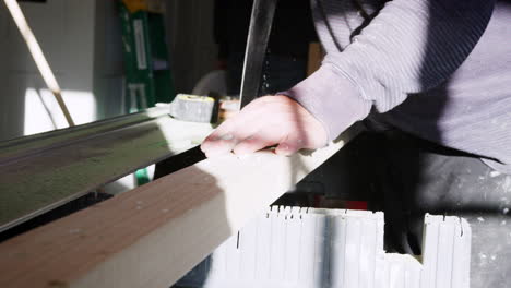 Close-Up-Of-Carpenter-Sawing-Timber-Indoors