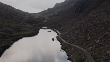 aerial view of a scenic irish valley with lake and winding road