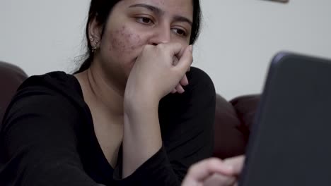 a teenage girl engages with her ipad while comfortably seated on the sofa, highlighting the integration of digital media into household settings for interactive multimedia and educational pursuits