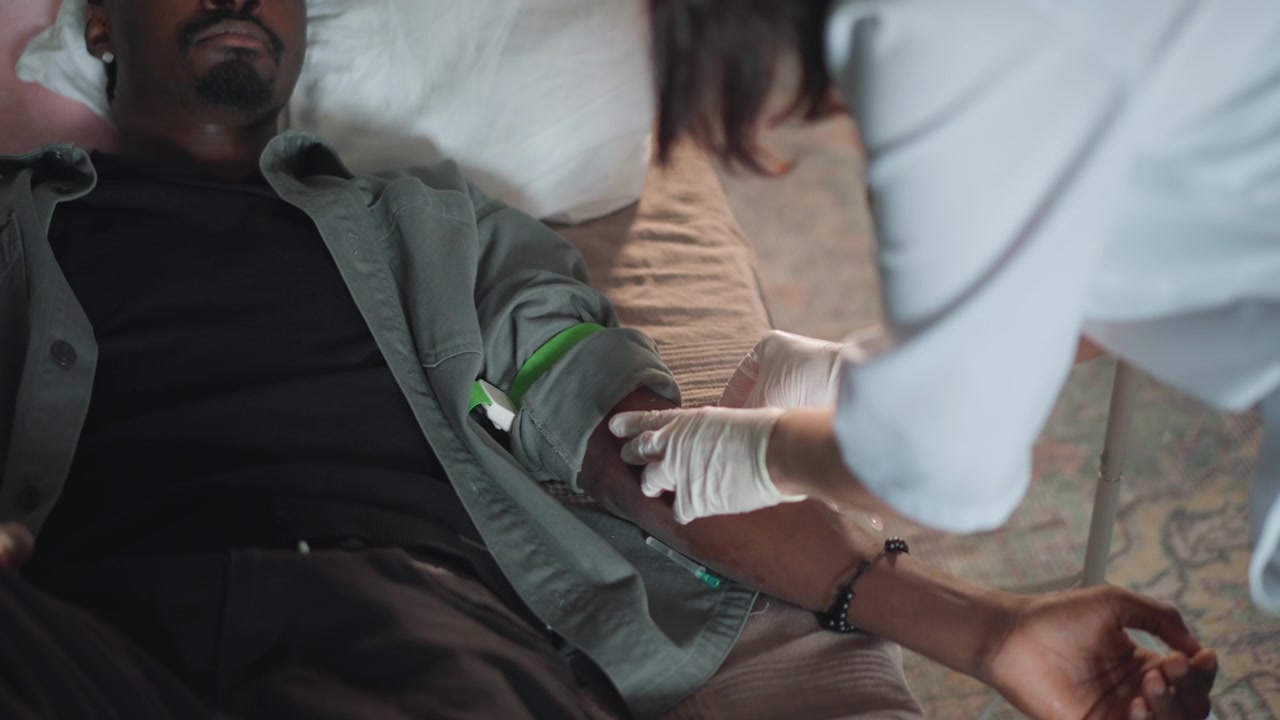 Inserção Urgente de Acesso Venoso. Equipe Médica de Emergência Realiza a Inserção Prontamente. Paciente em Sofrimento Recebe Acesso Intravenoso Urgente. Cena Tensa Onde Paramédicos Inserem Habilmente o Acesso Venoso em Situação de Emergência