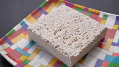 un bloque de tofu en un plato de colores