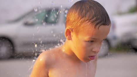 niño tomando una ducha al aire libre en la playa