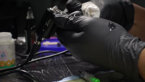 un artista del tatuaje limpiando su máquina de tatuaje