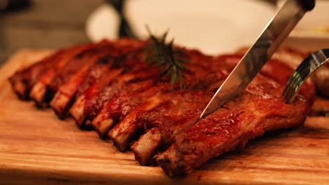 carving juicy ribs on a wooden board