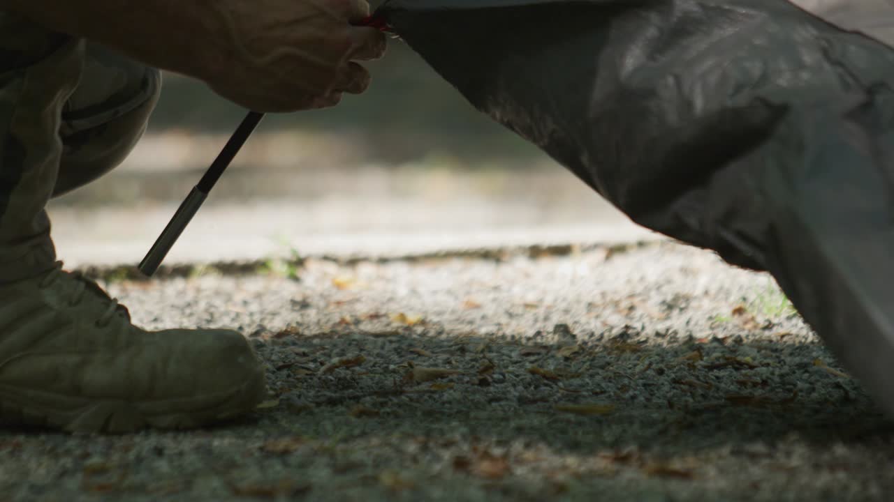 A camper setting up a tent, close up slow motion, mountains, camping