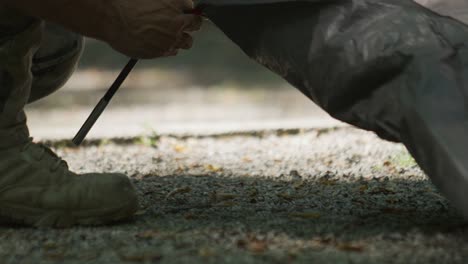 a camper setting up a tent, close up slow motion, mountains, camping