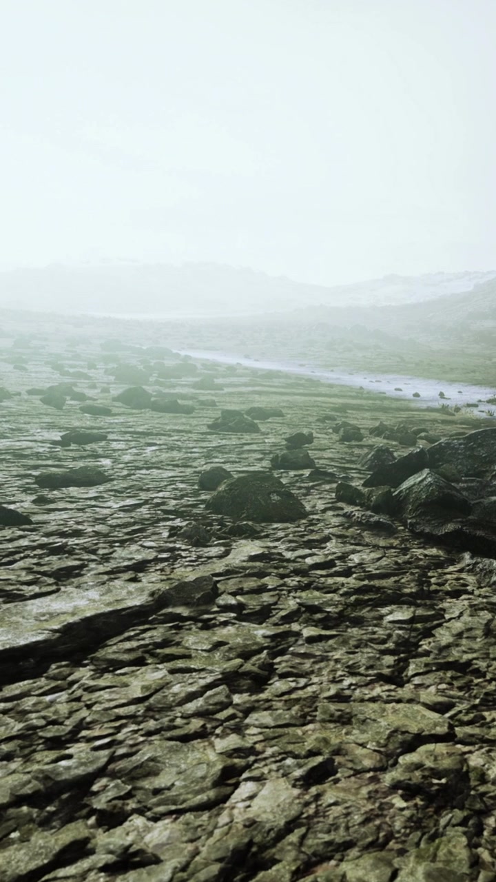 Rocky landscape with a distant view of a river and mountains in the background