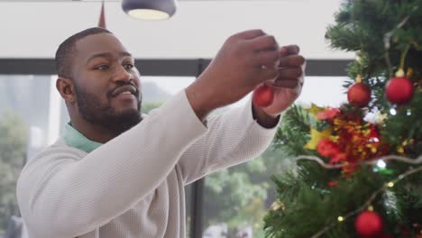 Video-De-Un-Hombre-Afroamericano-Feliz-Decorando-Un-árbol-De-Navidad-En-Casa