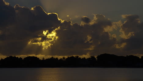 sun rays stream out from behind clouds over inlet in south florida, u