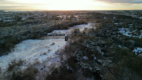 uk snowy blast brings winter wonderland - view of merseyside from bidston hill, wirral - aerial drone rotate around windmill in golden hour