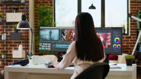 Female-video-editor-focuses-on-color-grading-while-working-on-a-film-project