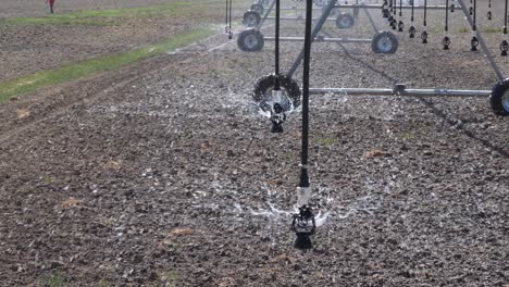 close up view of sprinkler pivot at work, watering crop for more growth