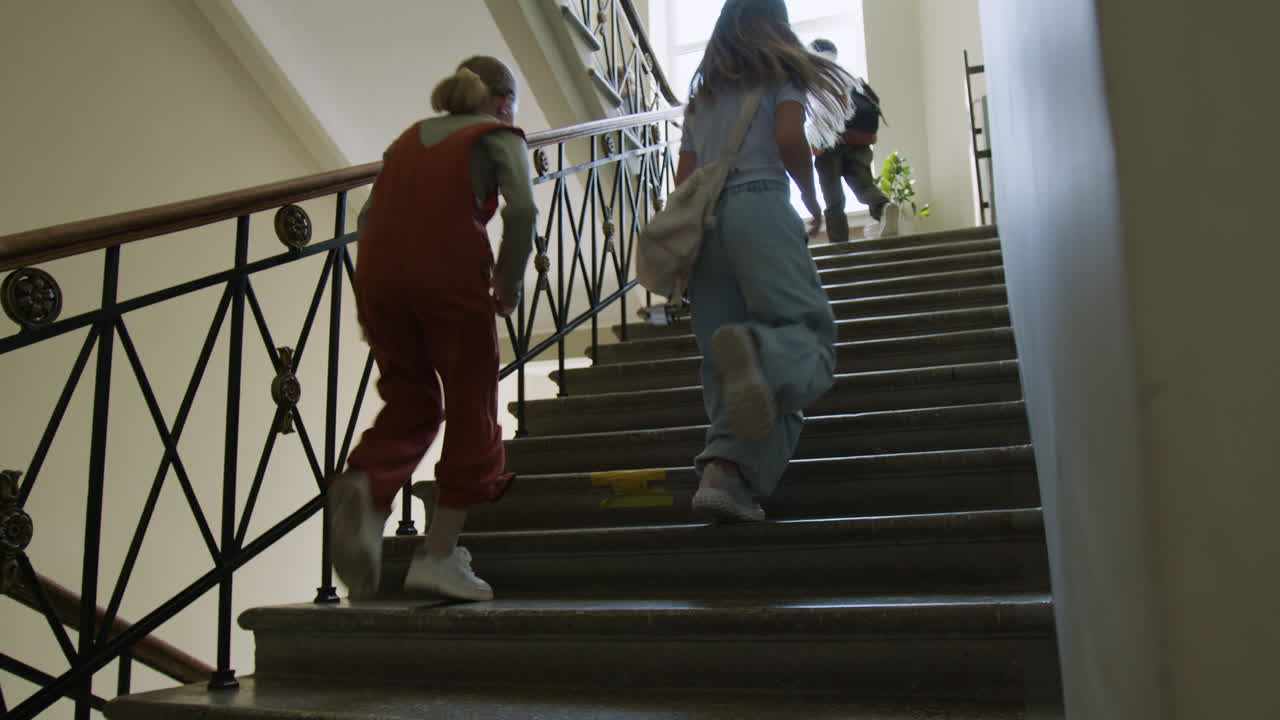 Students running up stairs in a school building