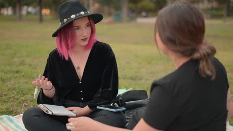 two young women talking in a park