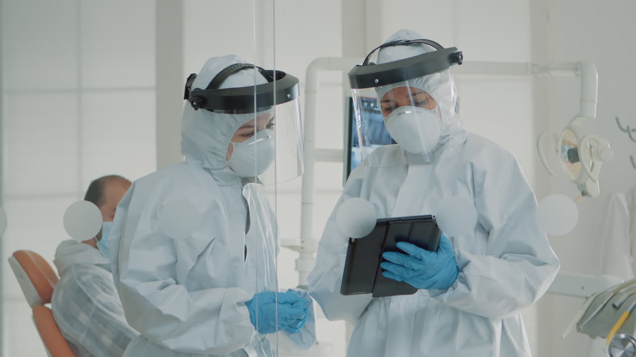 estomatólogos profesionales que utilizan tableta digital en el gabinete dental