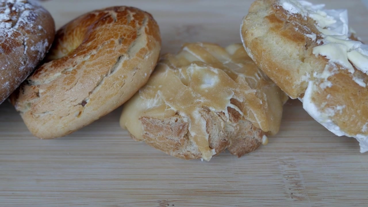 Assorted fresh traditional spanish biscuits with icing spread arranged on a wooden board