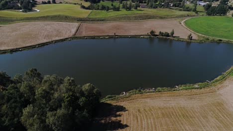 Aerial-view-of-Kashubian-Lake-district-with-green-natural-meadows-and-plowed-land-in-Poland-countryside