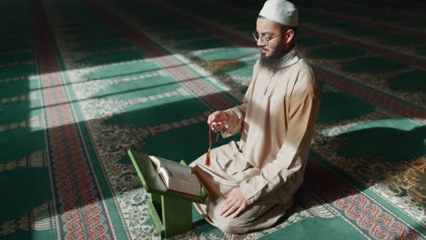 islam, praying and man in mosque with quran