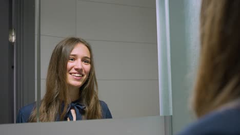 Mujer-Caucásica-De-Tiro-Medio-Sonriendo,-Choca-Los-Cinco-En-El-Espejo