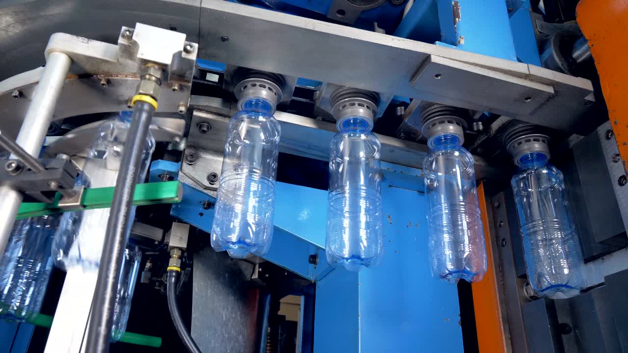 Plant machinery transporting PET bottles.
