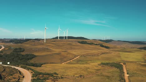 Beautiful-drone-aerial-view-of-dirt-roads-with-wind-turbine-generators-located-in-Santa-Catarina,-Brazil