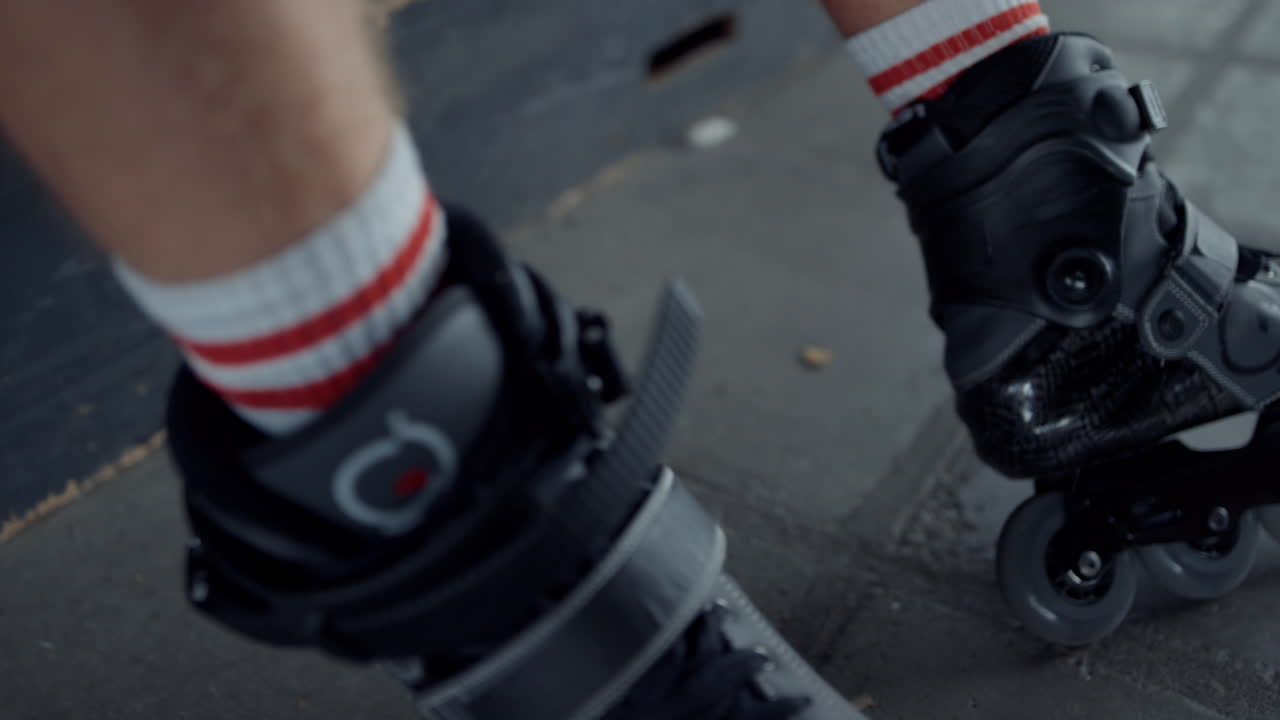 Sporty man relaxing at skatepark. Unrecognizable man legs in roller skates.