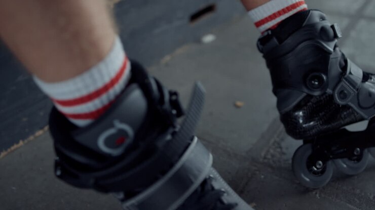 Sporty man relaxing at skatepark. Unrecognizable man legs in roller skates.