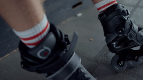 Sporty-man-relaxing-at-skatepark.-Unrecognizable-man-legs-in-roller-skates.