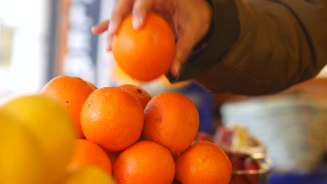 persona comprando naranjas en una tienda de comestibles